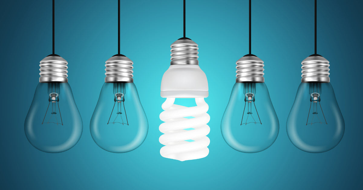 A row of hanging light bulbs, with one modern spiral bulb in the center standing out among traditional glass bulbs, symbolizing a shift away from the standard approach.